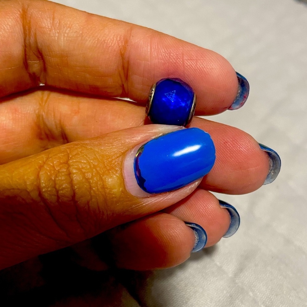 Abstract silver charm with faceted opalescent royal blue crystal